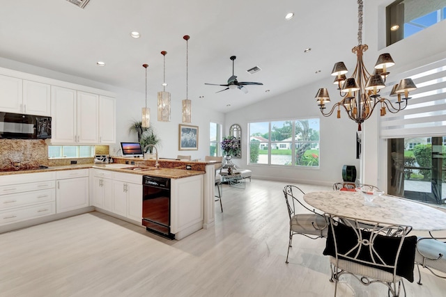 kitchen featuring a sink, white cabinets, open floor plan, black appliances, and decorative light fixtures