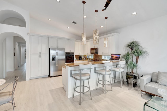 kitchen with arched walkways, visible vents, hanging light fixtures, white cabinetry, and black appliances