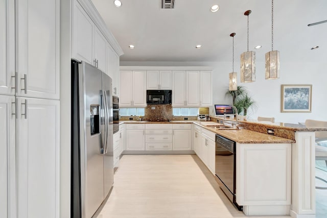 kitchen featuring black appliances, a breakfast bar area, white cabinetry, and decorative light fixtures