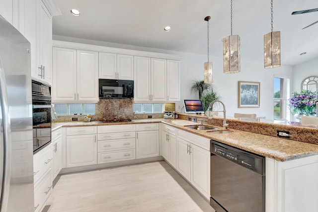 kitchen featuring white cabinetry, a sink, hanging light fixtures, and black appliances