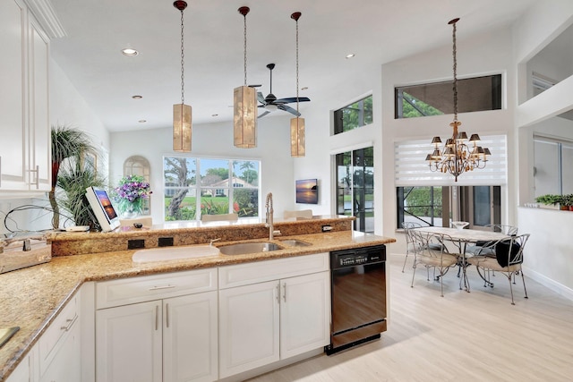kitchen featuring plenty of natural light, light stone counters, white cabinets, and dishwasher