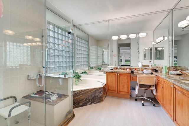 bathroom with a garden tub, a shower stall, vanity, and wood finished floors