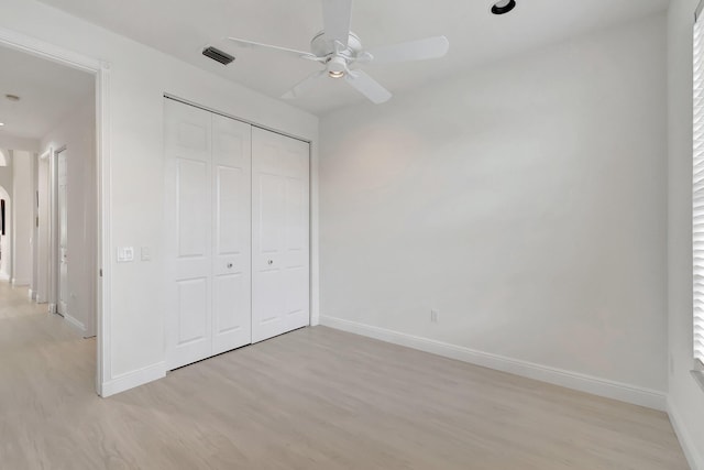 unfurnished bedroom with visible vents, baseboards, a ceiling fan, light wood-style flooring, and a closet