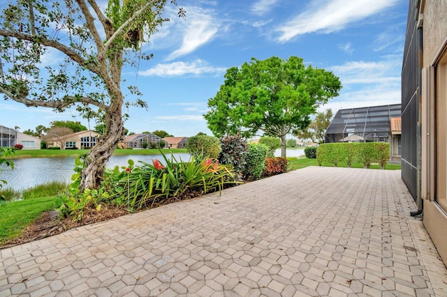 view of patio / terrace featuring glass enclosure, a water view, and a residential view