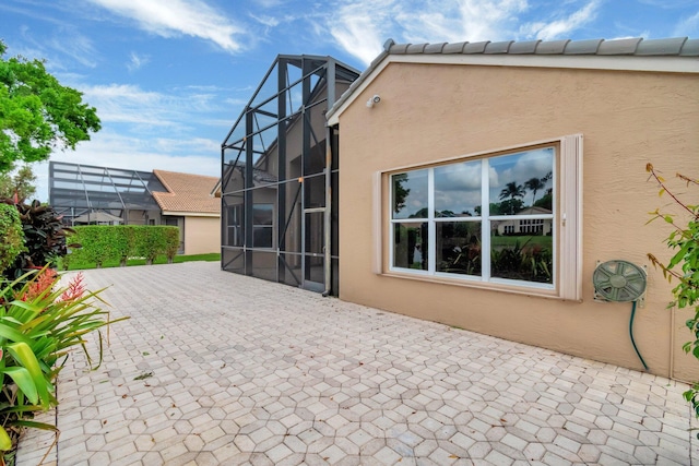 back of house with a patio, a tile roof, and stucco siding
