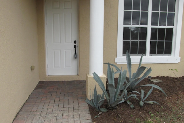 view of exterior entry with stucco siding