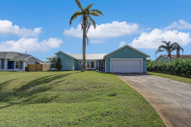 ranch-style house featuring metal roof, a garage, driveway, stucco siding, and a front yard