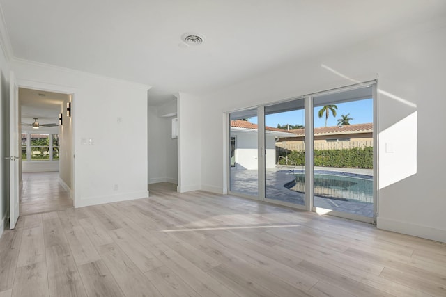 unfurnished room featuring light wood-style floors, ornamental molding, and baseboards