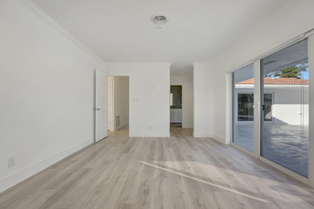 unfurnished room with ornamental molding, visible vents, light wood-style flooring, and baseboards