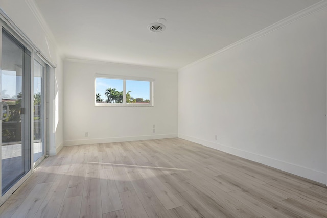 spare room featuring baseboards, light wood finished floors, visible vents, and crown molding