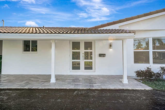 entrance to property with a patio area and stucco siding