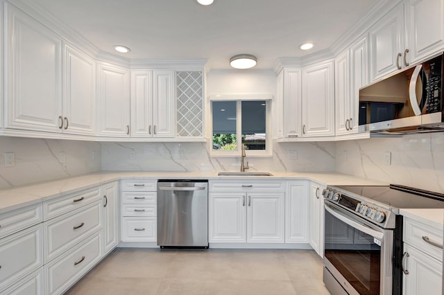 kitchen with white cabinets, decorative backsplash, stainless steel appliances, and a sink