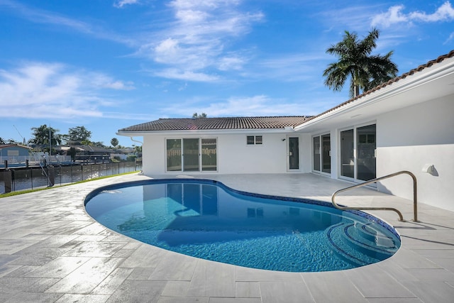 view of swimming pool featuring a fenced in pool, a patio area, a water view, and fence