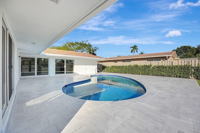 view of swimming pool with a fenced in pool, a patio, and fence