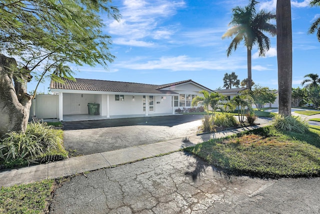 view of front of house featuring a tile roof, aphalt driveway, and stucco siding