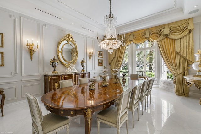 dining space with marble finish floor, a decorative wall, crown molding, and an inviting chandelier