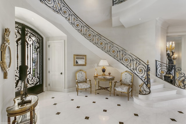 entryway featuring stairs, a high ceiling, and crown molding