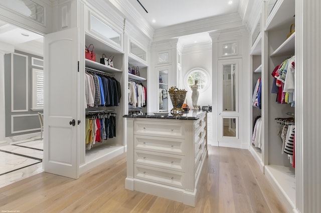 walk in closet with light wood finished floors