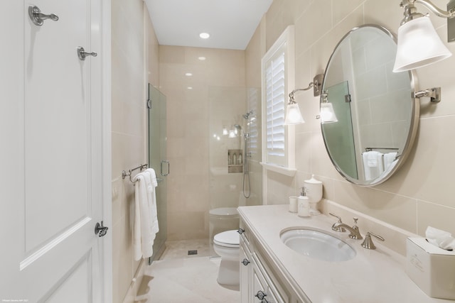 full bath with tile walls, toilet, a shower stall, vanity, and tile patterned flooring