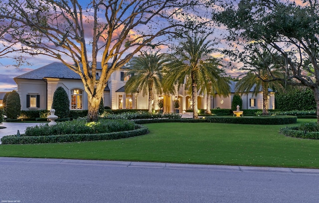 view of front of home with a lawn and stucco siding