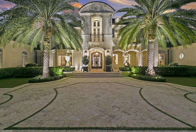 exterior space featuring a balcony, stucco siding, and french doors