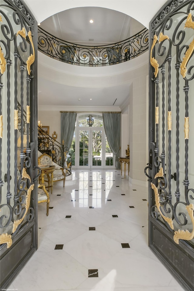 entryway with ornamental molding and french doors