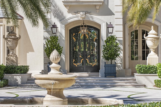 entrance to property featuring french doors and stucco siding