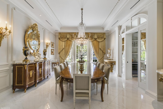 dining room featuring a decorative wall, marble finish floor, ornamental molding, a raised ceiling, and an inviting chandelier