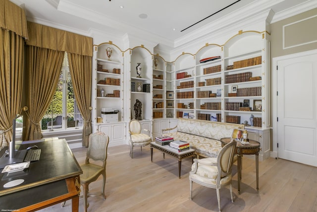 living area featuring built in shelves, ornamental molding, and light wood-style flooring