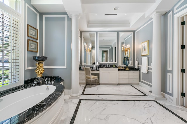 bathroom featuring marble finish floor, decorative columns, a raised ceiling, and a bath