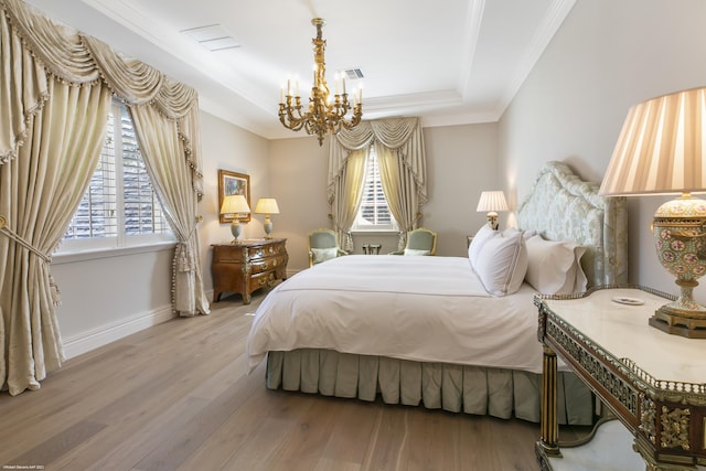 bedroom with light wood-style floors, multiple windows, ornamental molding, and a raised ceiling