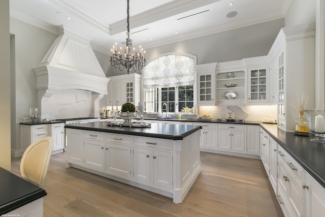 kitchen featuring glass insert cabinets, dark countertops, and white cabinetry