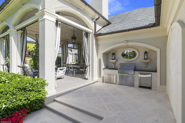 view of patio featuring a sink, outdoor dining area, exterior kitchen, and area for grilling