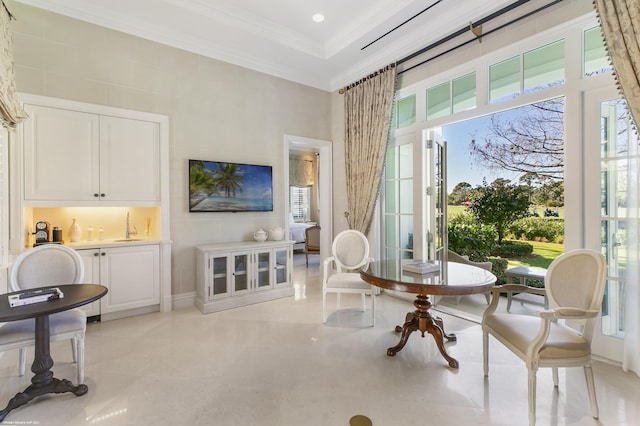 sitting room with plenty of natural light, concrete floors, a high ceiling, and crown molding