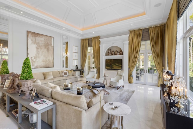 living area with built in features, coffered ceiling, ornamental molding, french doors, and a notable chandelier