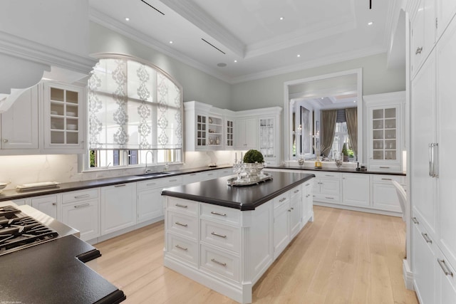 kitchen with dark countertops, glass insert cabinets, and white cabinets