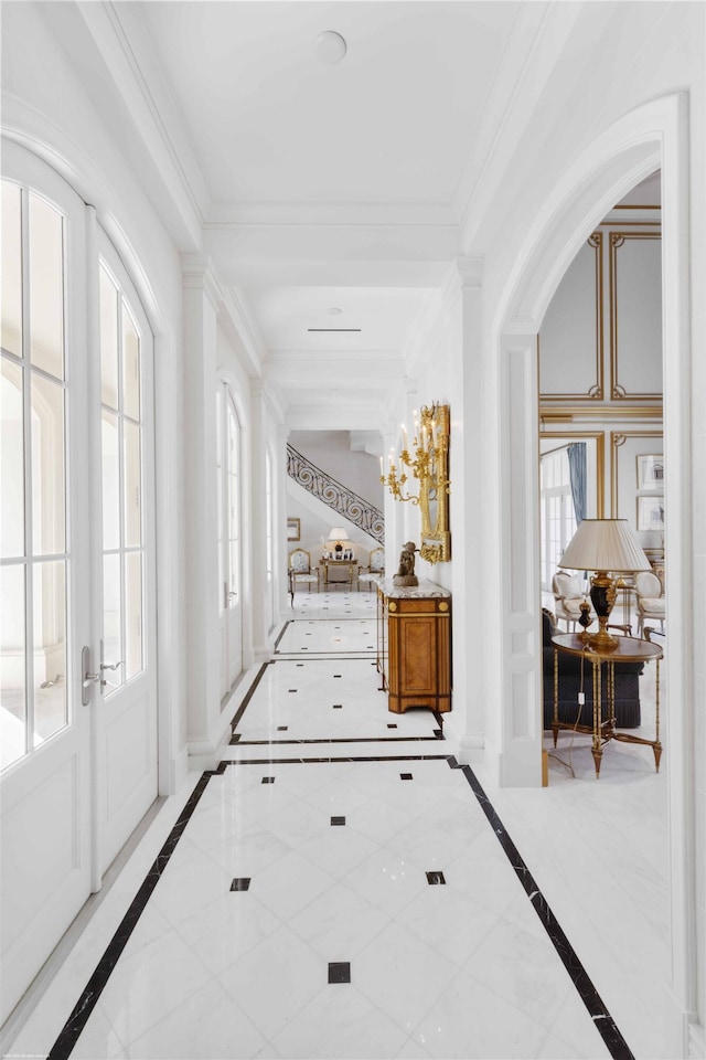 corridor featuring arched walkways, french doors, and crown molding