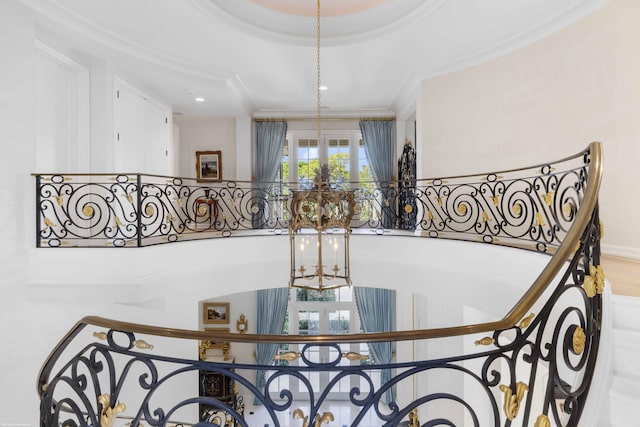 stairway with a chandelier and ornamental molding