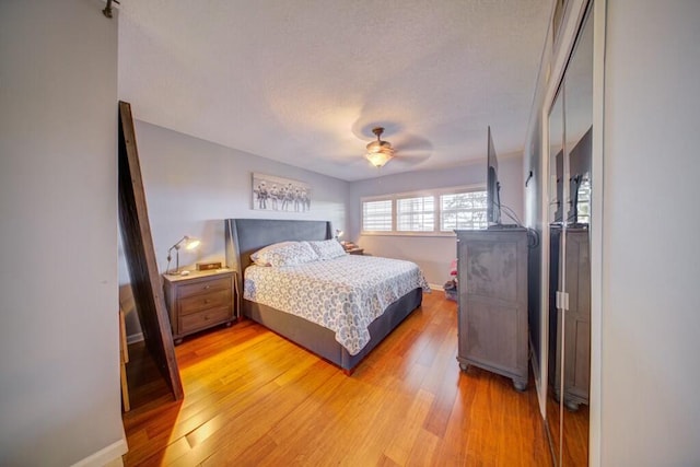 bedroom featuring ceiling fan, light wood-style flooring, and baseboards