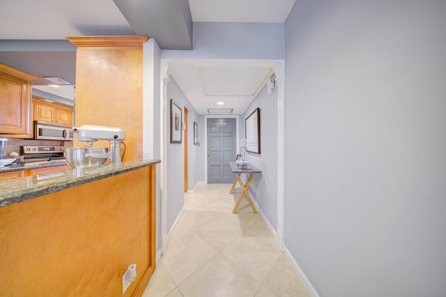 hall with light tile patterned floors and baseboards