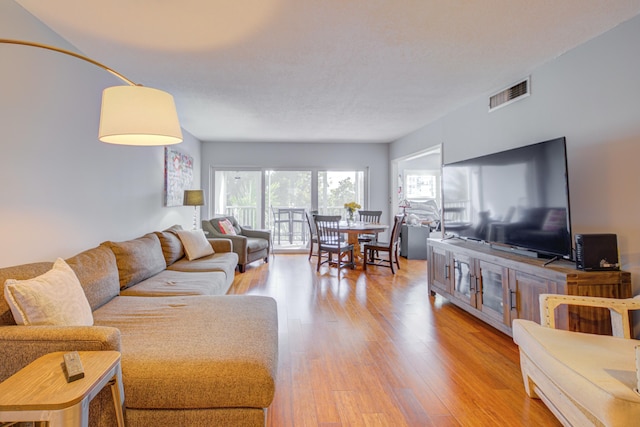 living room with light wood-type flooring and visible vents