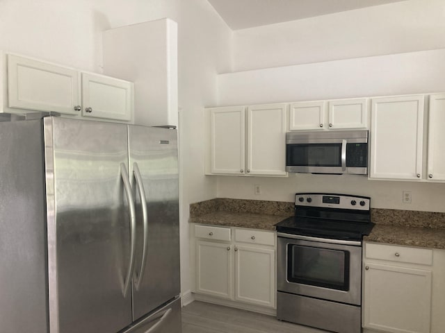 kitchen with light wood finished floors, white cabinetry, and appliances with stainless steel finishes