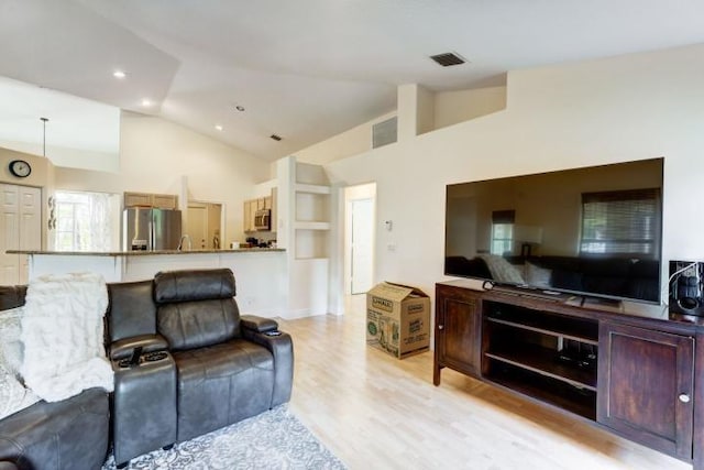 living room featuring light wood-style floors, visible vents, high vaulted ceiling, and recessed lighting