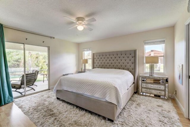 bedroom with a textured ceiling, a ceiling fan, baseboards, access to exterior, and light wood finished floors