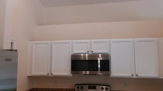 interior details with appliances with stainless steel finishes and white cabinetry