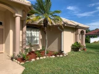 view of side of home featuring a lawn and stucco siding