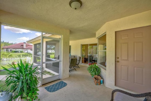 doorway to property featuring a patio area, fence, and stucco siding