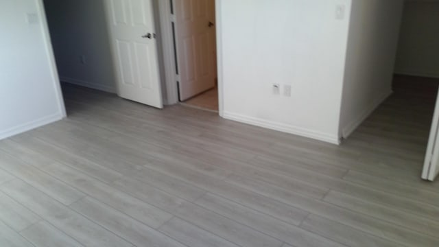 interior space featuring light wood-style flooring and baseboards