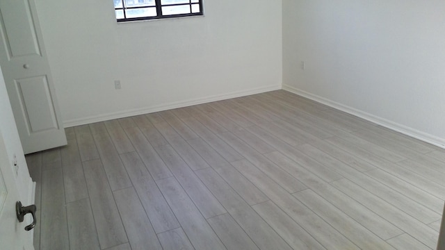 empty room featuring light wood-style floors and baseboards