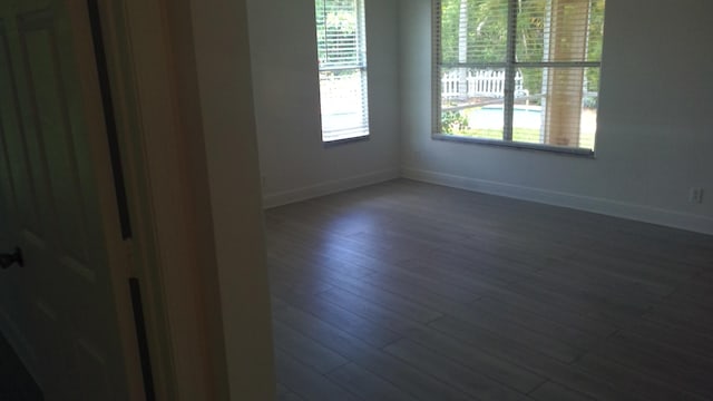 empty room with baseboards and wood finished floors